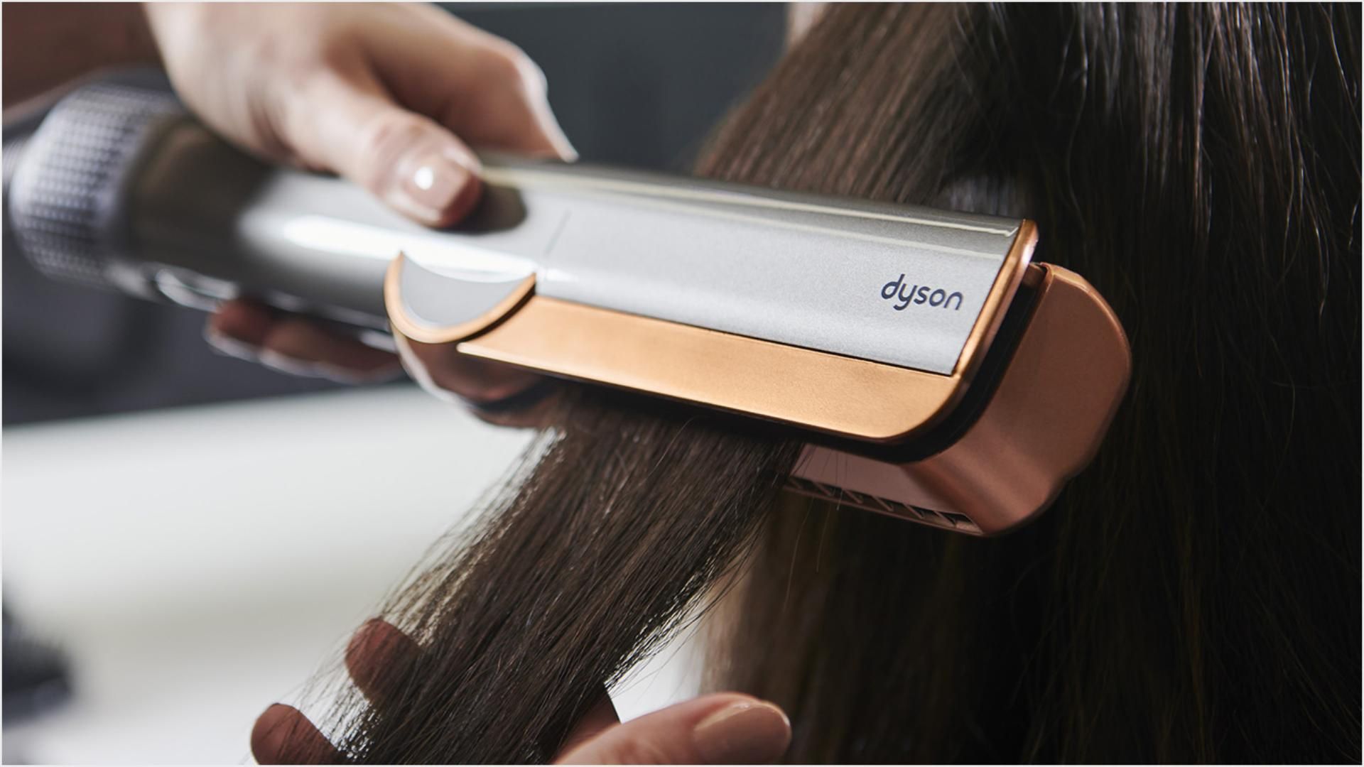 תקריב של דוגמנית משתמשת ב-Dyson Airstrait על השיער.